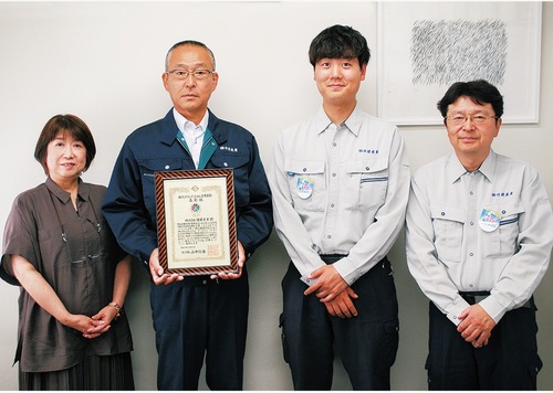 表彰状を手にした平田代表取締役（左から２人目）と日建産業の社員