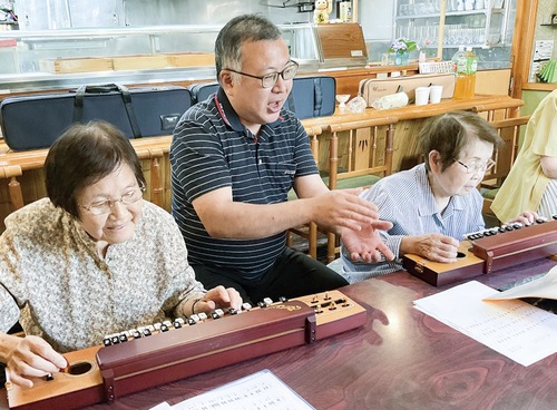 松井会主(中央)の手拍子に合わせて演奏する山野井さん(右)と岩澤さん(左)