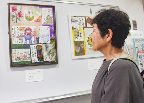 自身が出品した絵手紙作品を見る松本さん