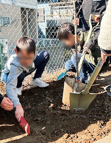 植樹する児童（提供写真を一部加工）