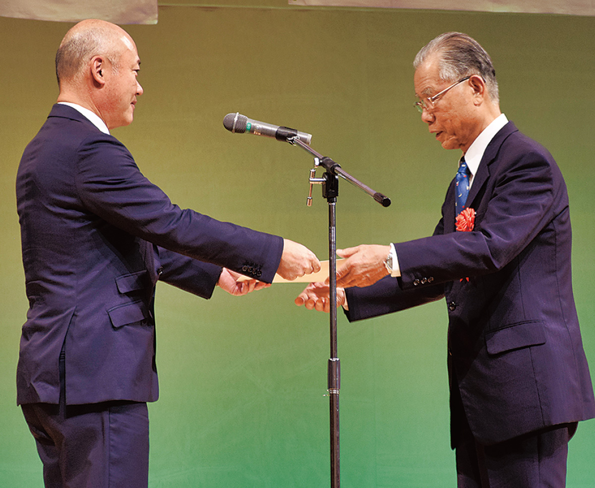 小野崎区長から表彰される狩野氏（右）