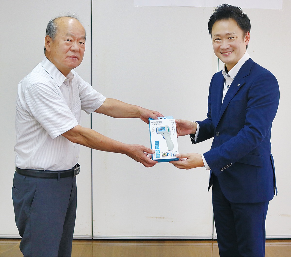温度計を手渡す橋本営業部長(右)と大谷会長