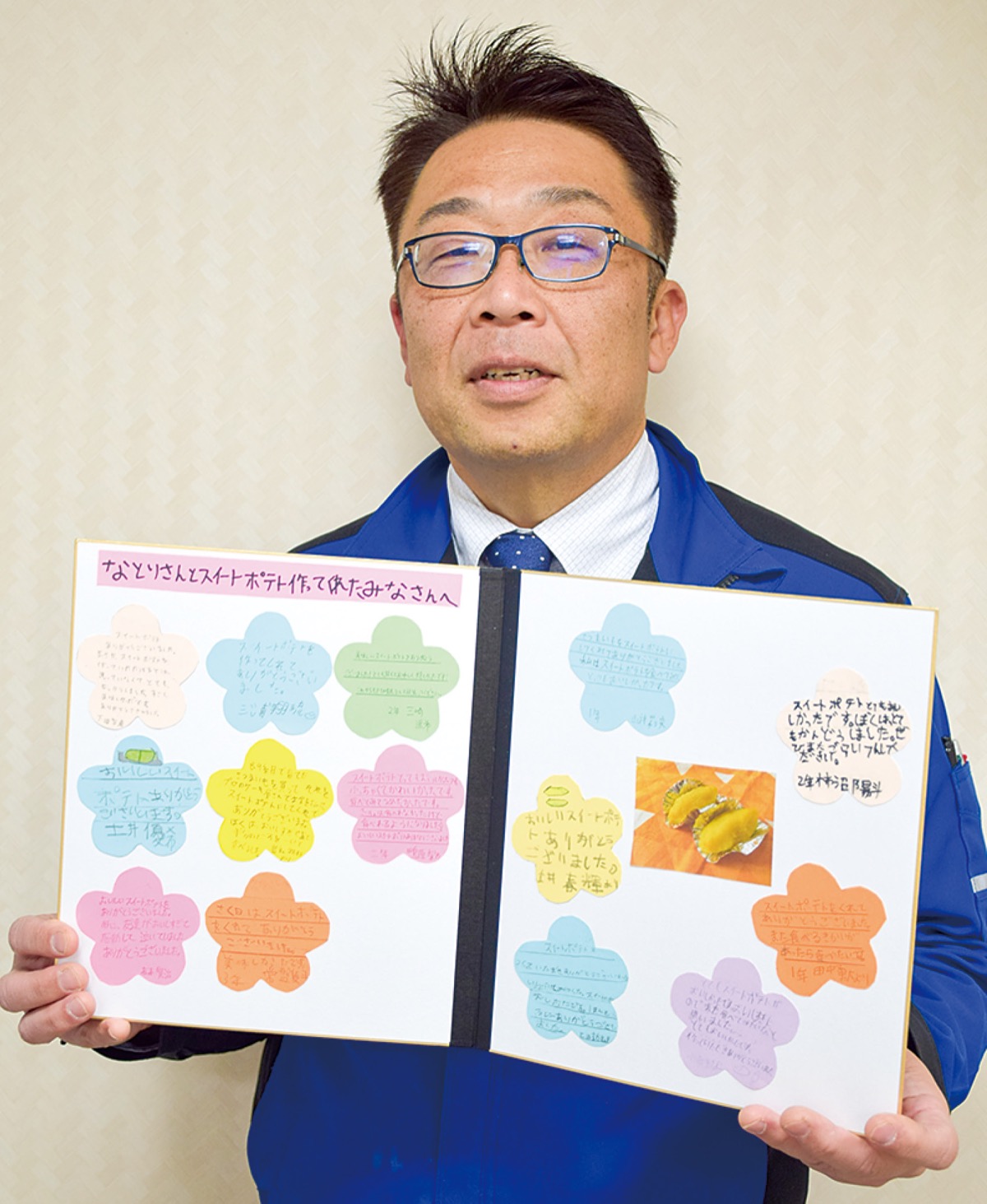 子どもたちにもらったメッセージ入りの色紙を手に笑顔の名取代表取締役