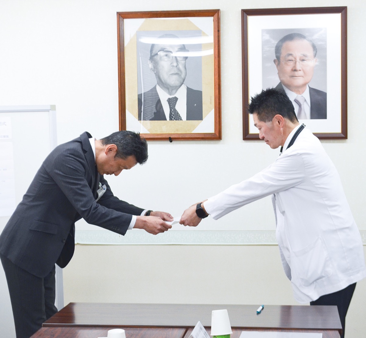 得能所長(左)に事業協力の意向を伝え、書面を手渡す戸田理事長