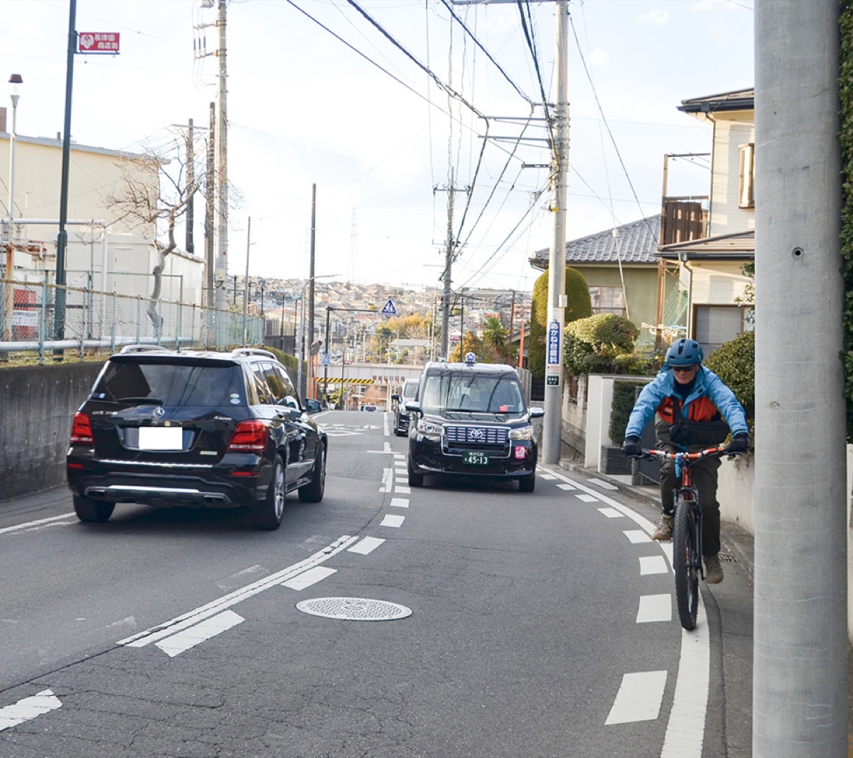 道幅が狭く注意深く通行する自転車と自動車