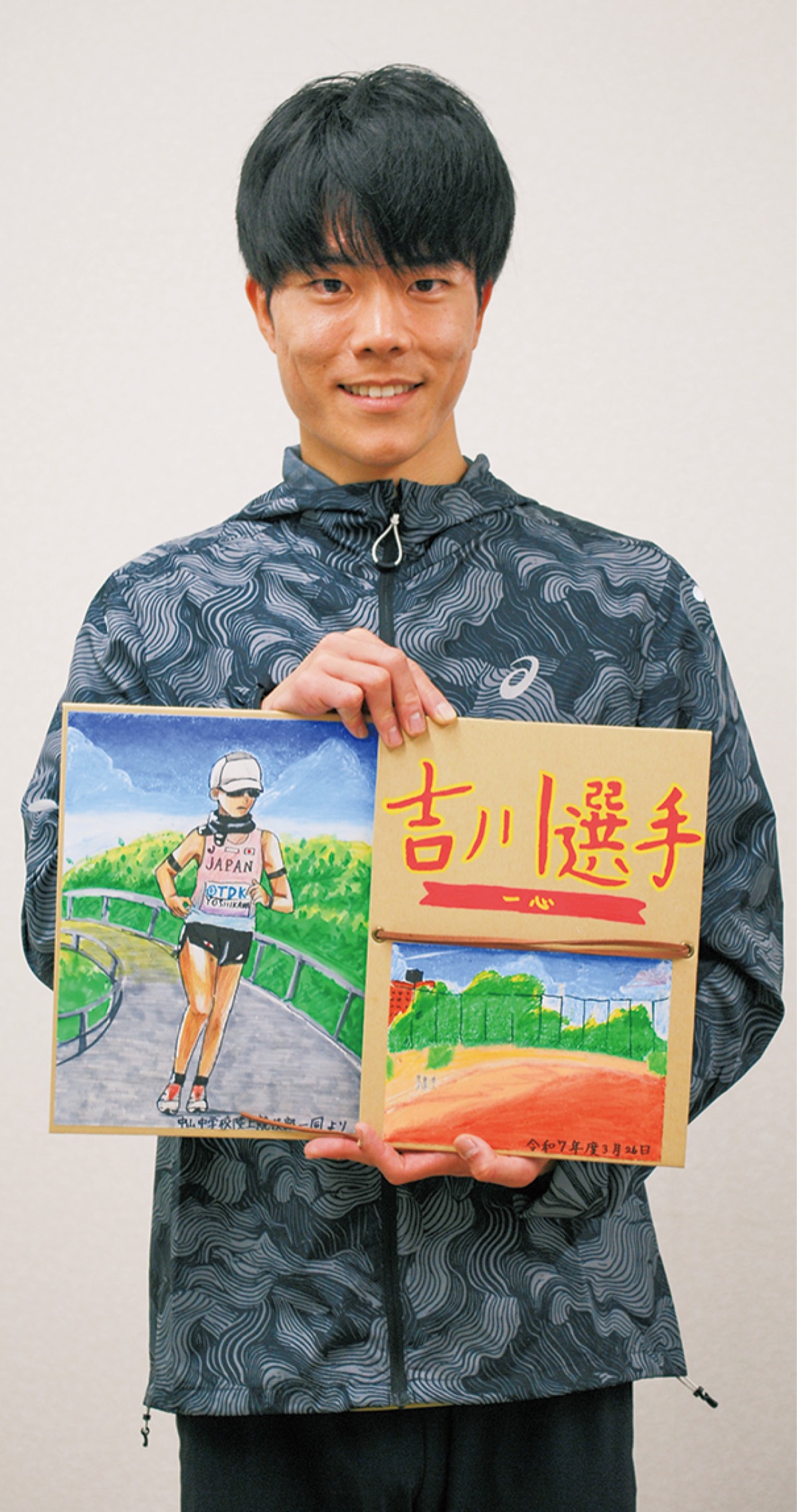 部員たちから贈られた記念品を手にする吉川選手