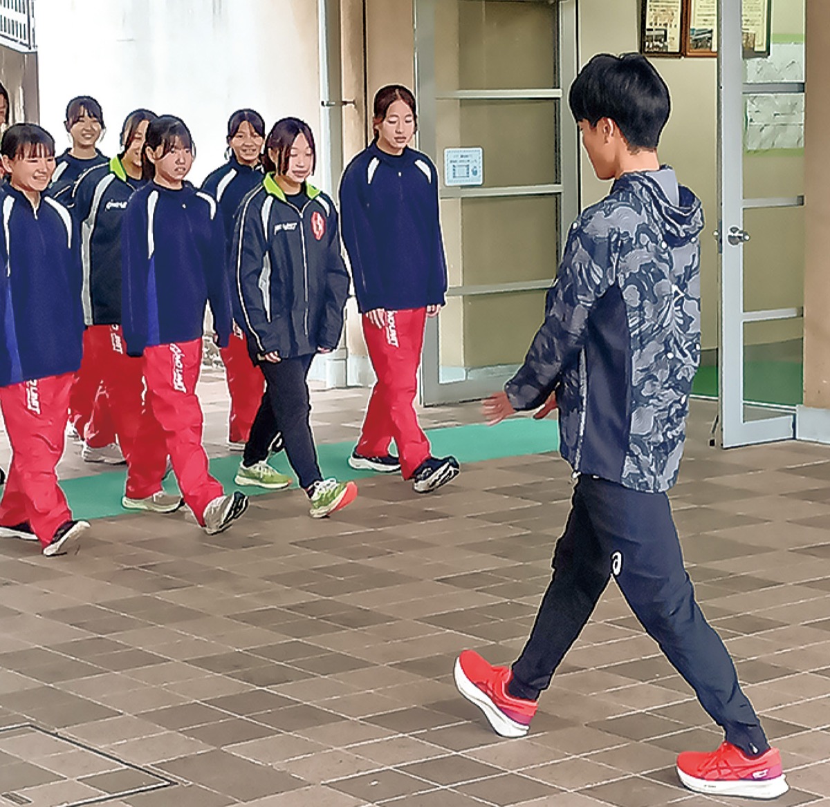 部員に競歩での歩き方を指導する吉川選手（右）