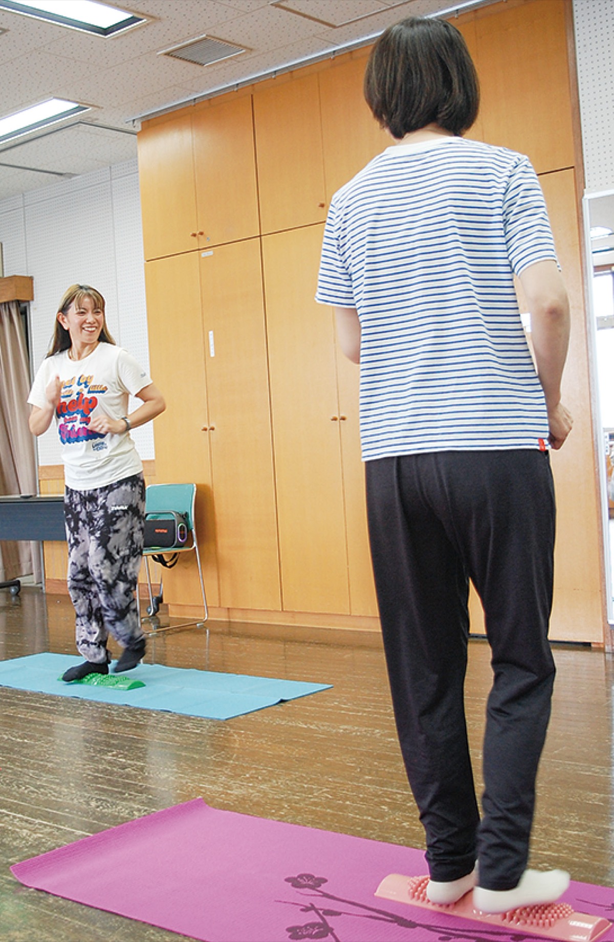 村松さん(左)の指導で青竹を踏む参加者