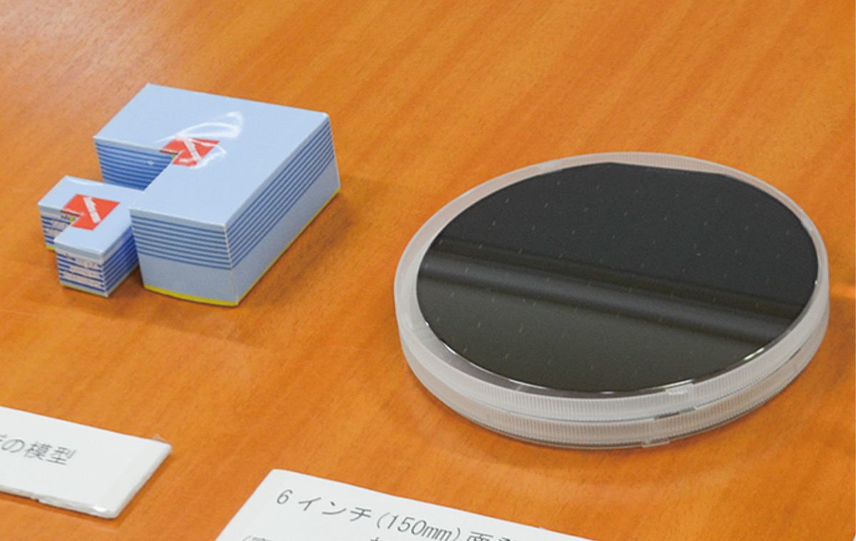 「面発光レーザー」の発光部を拡大した模型(左)と微小なレーザーを集積させた人体基板