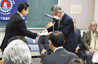 小川区長（左）から委嘱を受ける推進委員