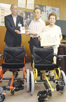 桐谷次郎県教育長（左）に目録を渡す千葉昭夫さんと圭子さん