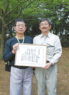 感謝状を手にする小幡さん（左）と安部理事長