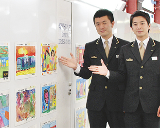 ポスターの前に立つ松田さん（左）と羽下さん