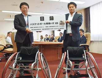 目録を手にする大八木理事長（左）と橋本代表取締役