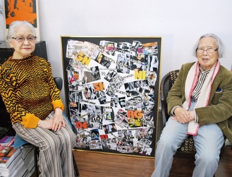 昨年出品したコラージュ作品「令和.99」の前に座る荒井さん（右）と妻の実子さん。作品の中央に「99」の文字がコラージュされている