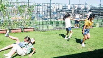 芝生の上で遊ぶ児童ら