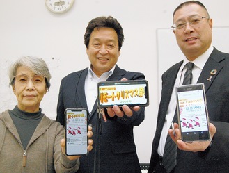 リモートクリスマス祭の広報物を表示したスマートフォンを手に町内会の取組みを紹介する（左から）福崎副会長、吉田会長、田口副会長