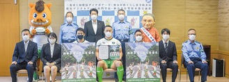 披露されたポスターを持つ選手と学生ら＝学校法人岩崎学園提供