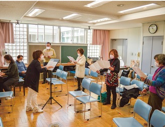 講師の指導のもと、歌うメンバーら