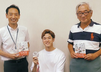 銀メダルを持つ古澤さんと後藤校長(左)、平野教諭(右)