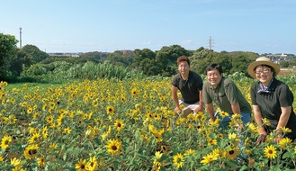 ひまわり畑を紹介する（右から）石川綾乃さんと穣さん、土志田さん＝７月22日撮影