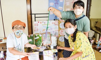 「東京スカイツリー」を作って見せる、あやとり教室指導員の大坂さん（左）ら