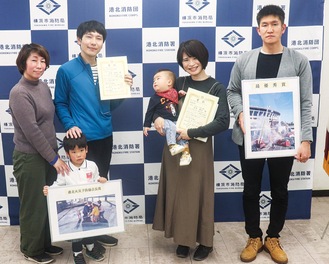 家族と一緒に喜ぶ吉岡さん（中央左）と岸本さん（同右）