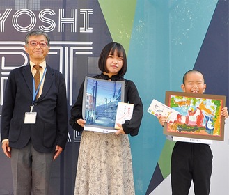 最優秀賞を受賞した佐藤さん(中央)と志村くん(右)。左はプレゼンターを務めた日吉サンロード商店会の厚川隆雄さん