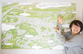 壁に描かれた城郷の絵地図と岩田さん