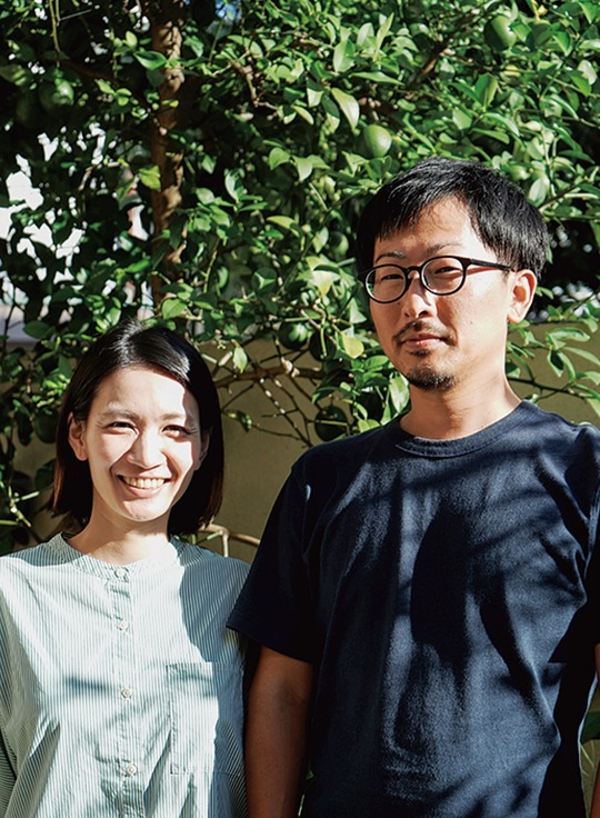 名称の由来となったレモンの木の前に立つ大森夫妻