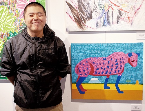 ポスターに使用された「ハイエナの女王」と作家の奥津大希さん