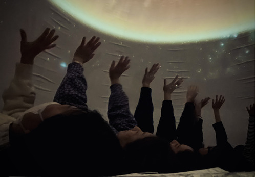寝転がりプラネタリウムを鑑賞する参加者