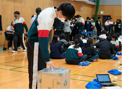 投票用紙を投函する児童