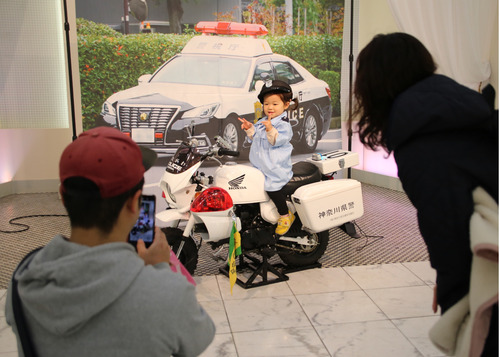 警察官になりきって記念撮影を行う親子