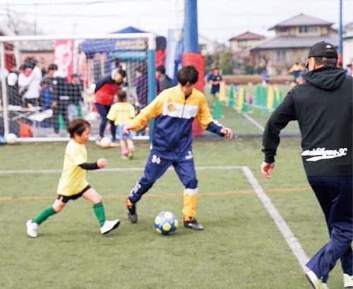 選手（中央）とサッカーを楽しむ参加者＝提供写真