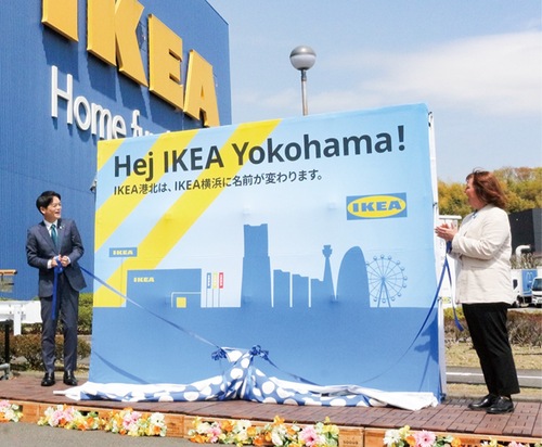 名称変更を伝えるボードの除幕に臨んだ山中竹春市長(左)とペトラ社長