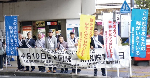 横断幕と幟を掲げるメンバーら