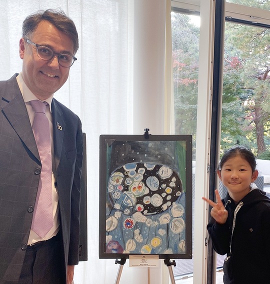 作品の前の藤川さん（右）とハインリッヒ・フッベ課長＝提供写真