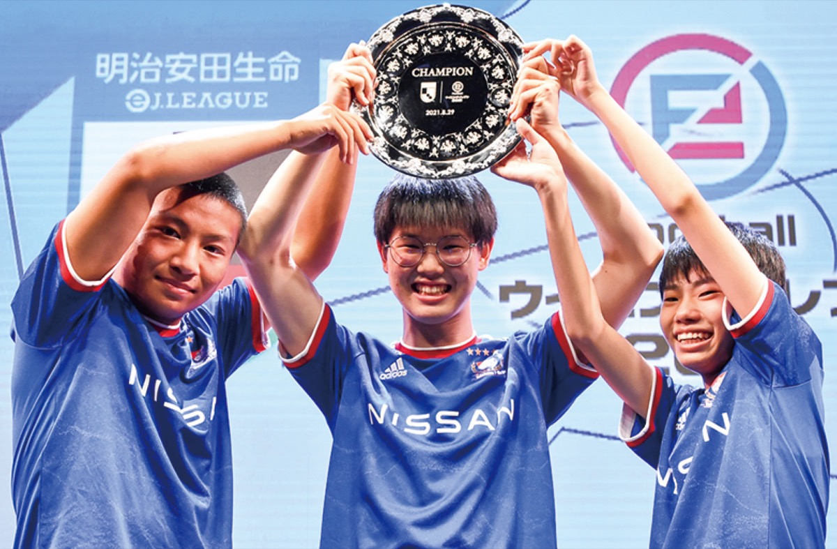 優勝トロフィーを掲げる（左から）徳地さん、外山さん、白鳥さん(C)J.LEAGUE/(C)Konami Digital Entertainment