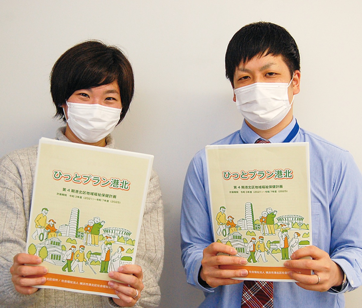 計画書を手にする港北区福祉保健課事業企画担当係長の久保村駿さん（右）と中嶋真理奈さん