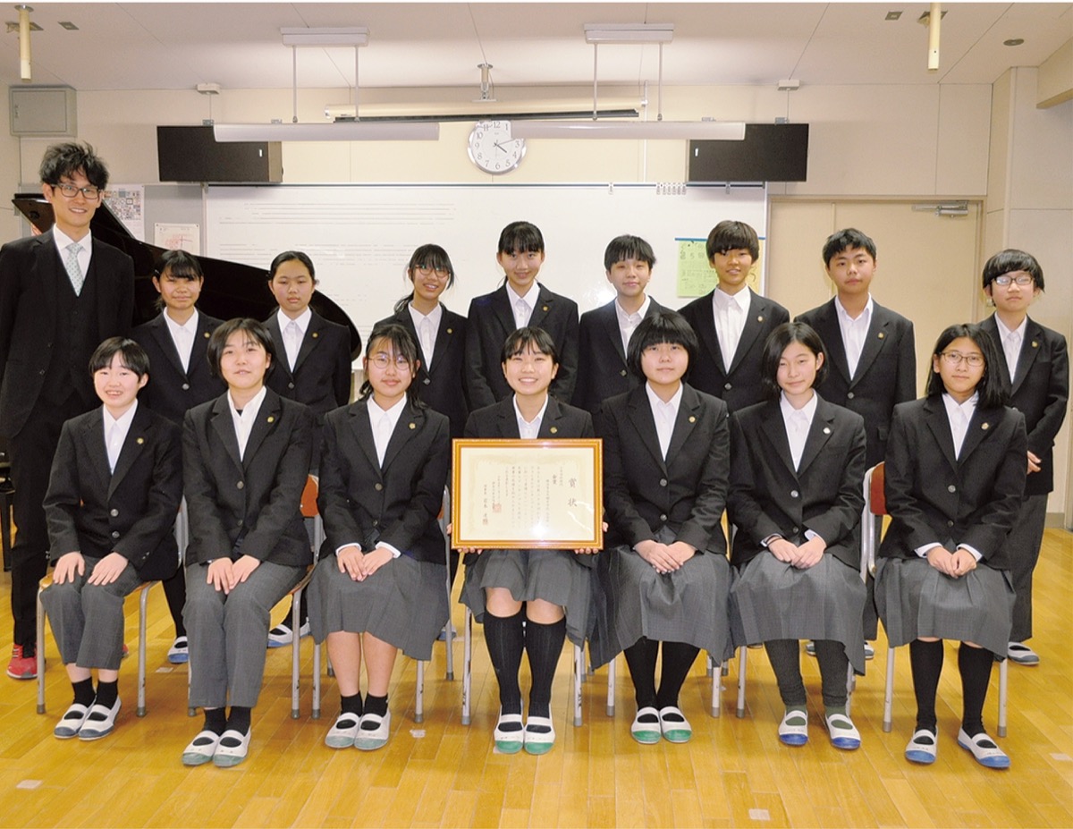 全国大会への出場を前に笑顔を見せる大綱中合唱部1年・2年生のメンバーと顧問の西川教諭(後列左)