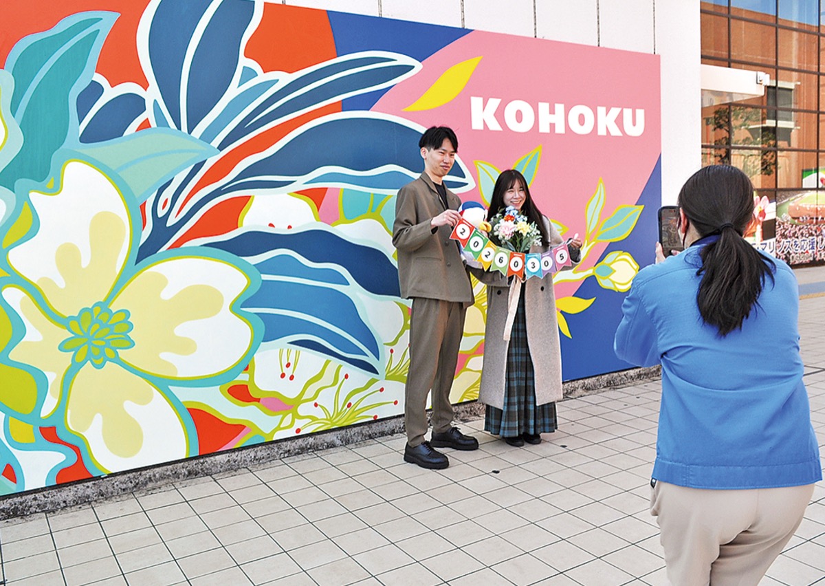 壁アートの前で写真撮影をする夫婦