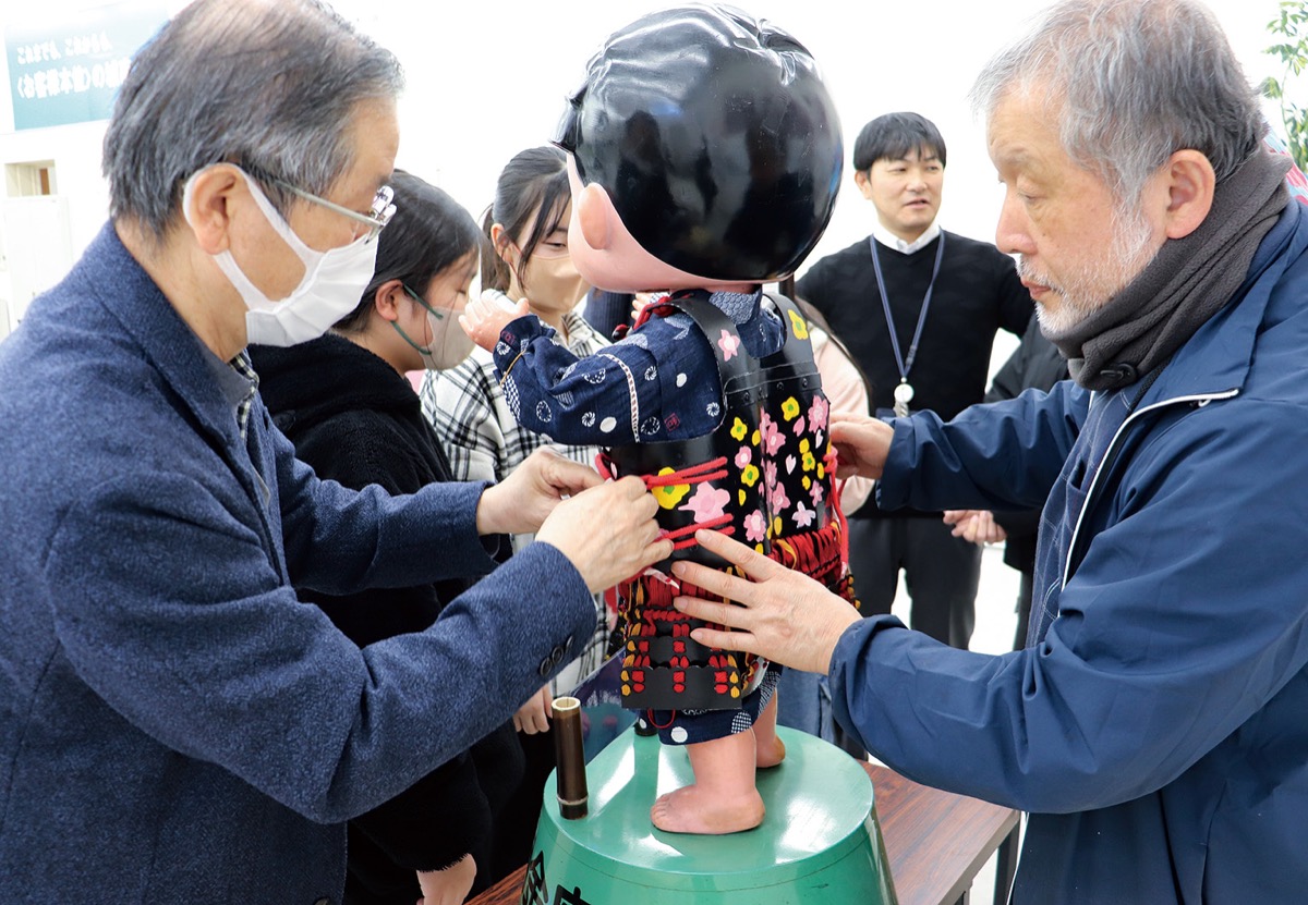 装着を手伝う「とんぼの会」の姫野和義さん（左）と飯島泰さん（右）