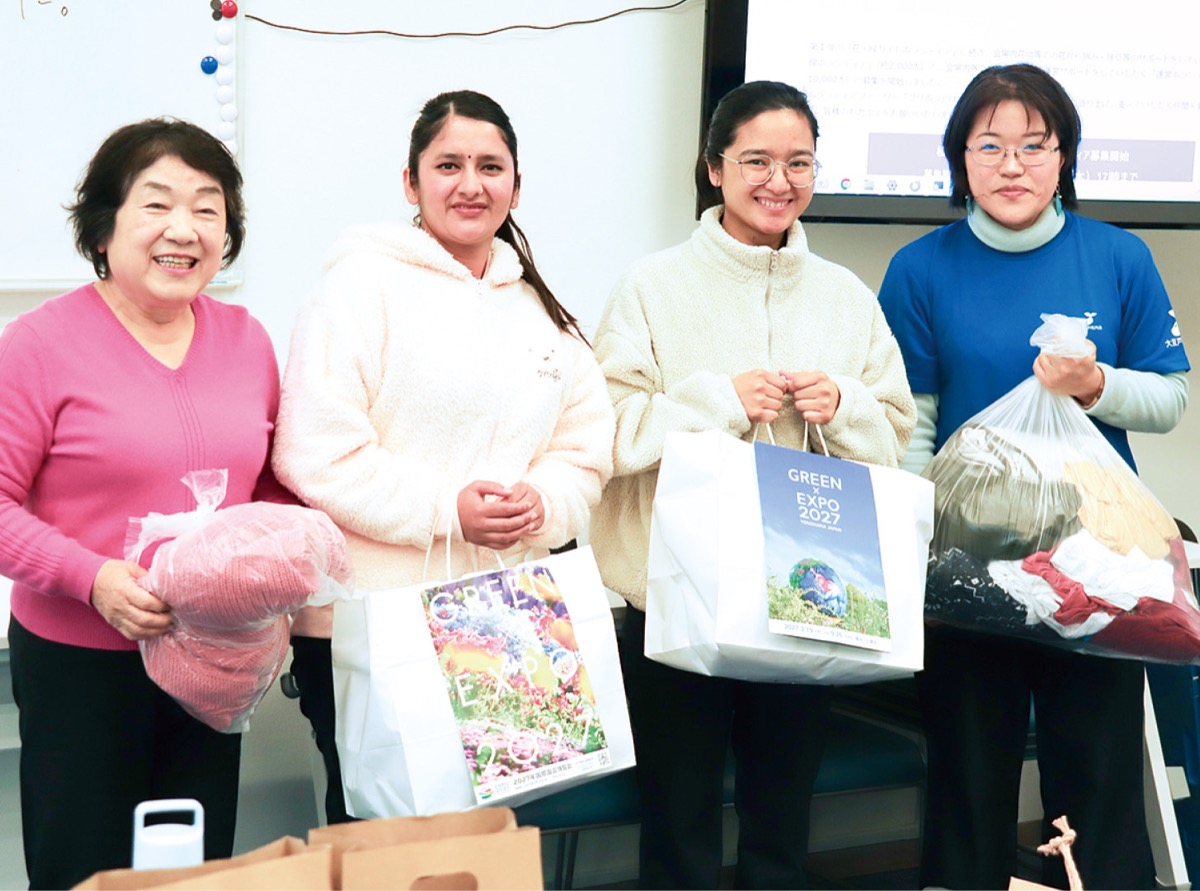 寄付する衣類を手にするメンバーら