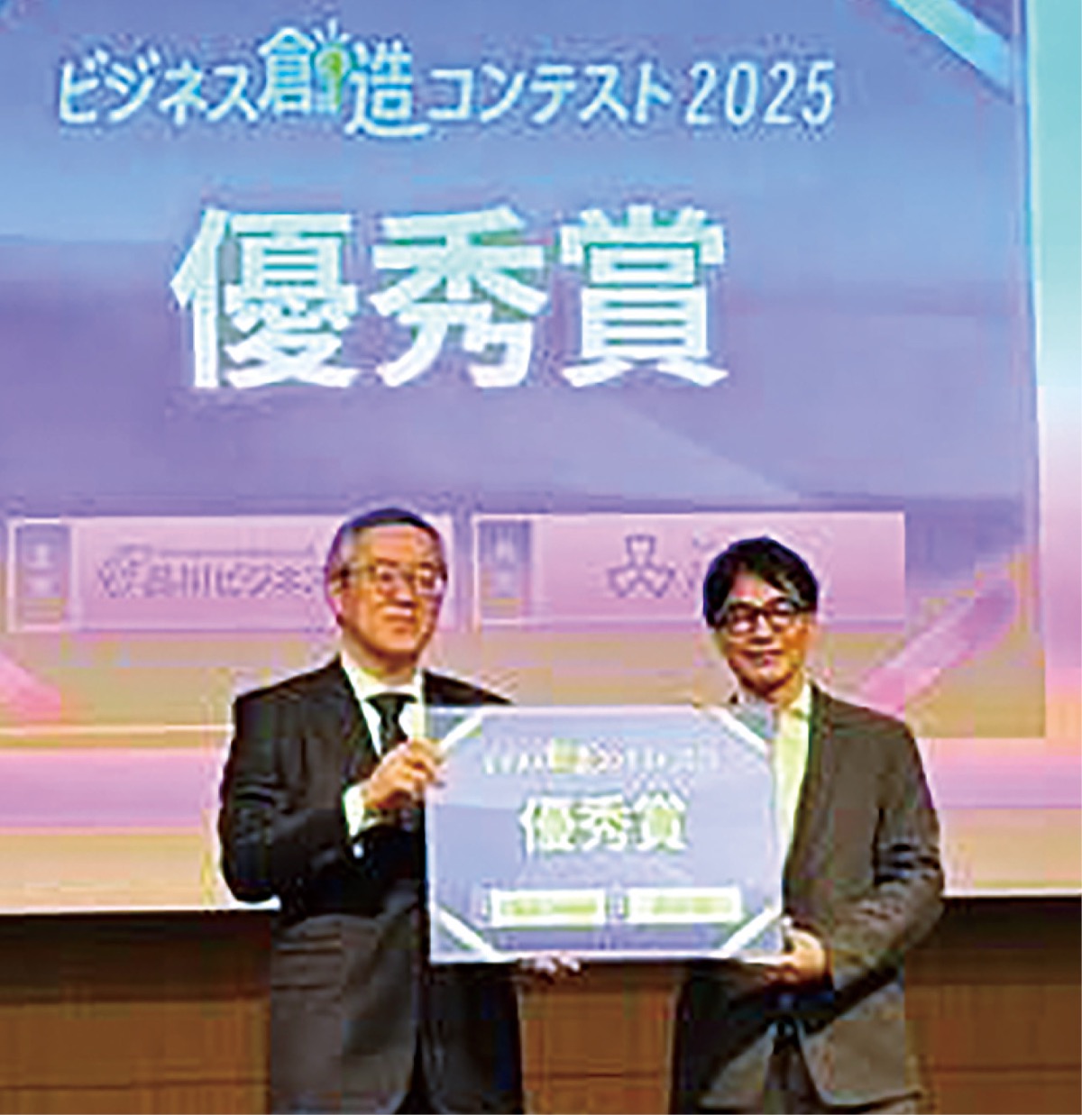 ビジネス創造コンテスト２０２５で優秀賞を受賞した際の山中代表（右）