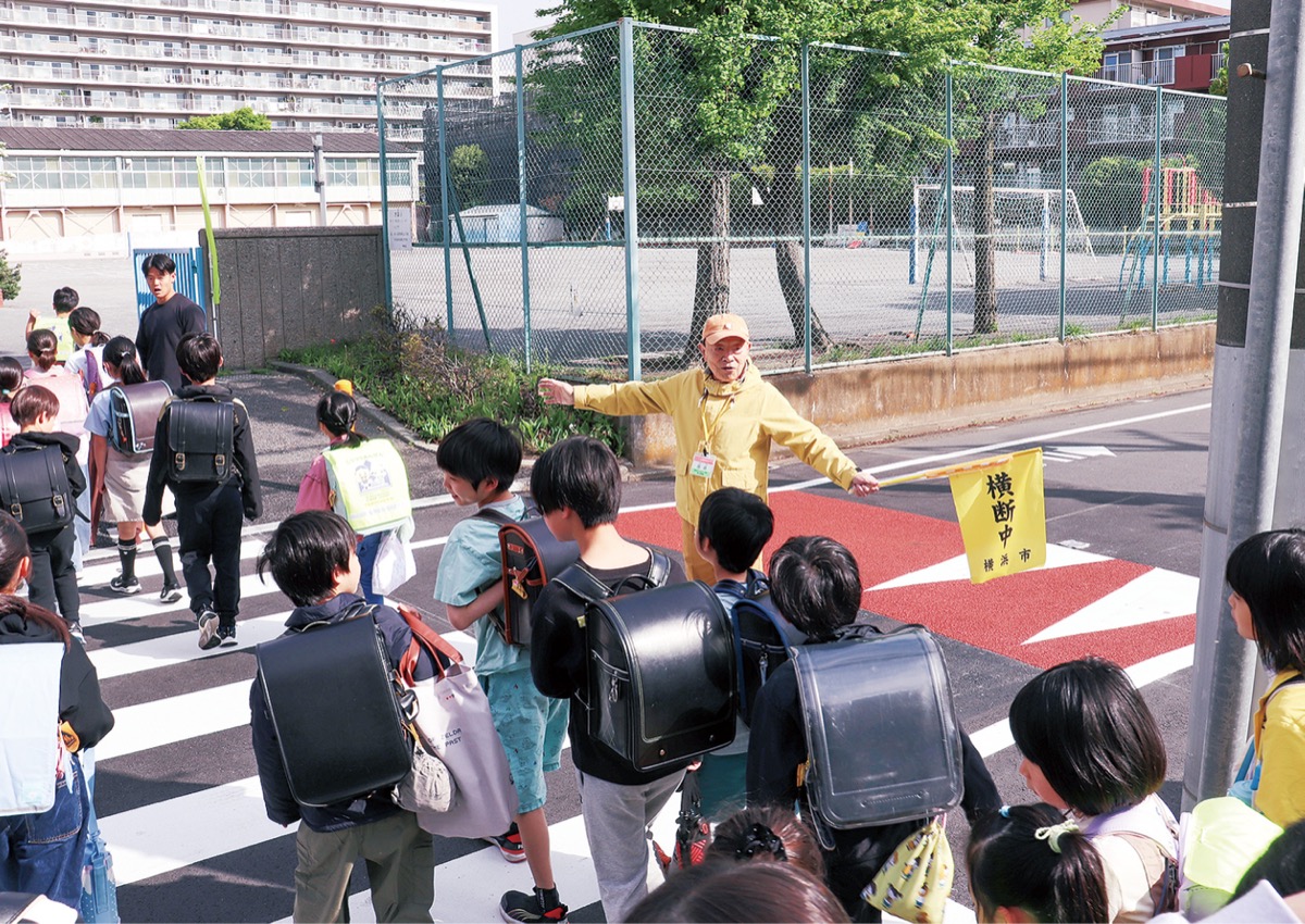 児童に声を掛けながら、登校を見守る篠崎さん＝４月17日