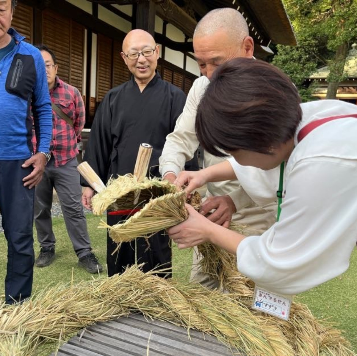 わら蛇作りの仕上げをする参加者ら