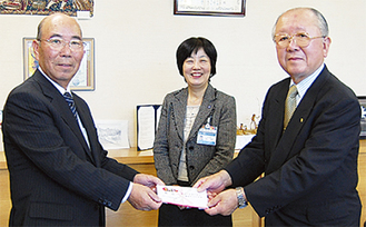 飯田会長（左）から志村会長に寄付金が手渡された