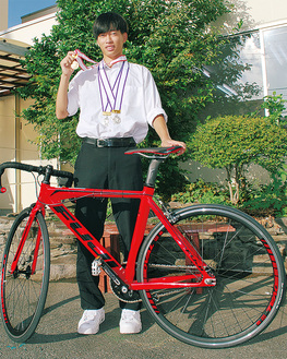 愛用の自転車とメダルを手にする瀬川さん