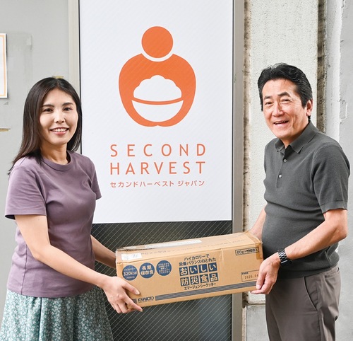 ＳＨＪの坂本瑶子マネジャー（左）に非常食を渡すAOKI　HDの荒木渉シニアアドバイザー